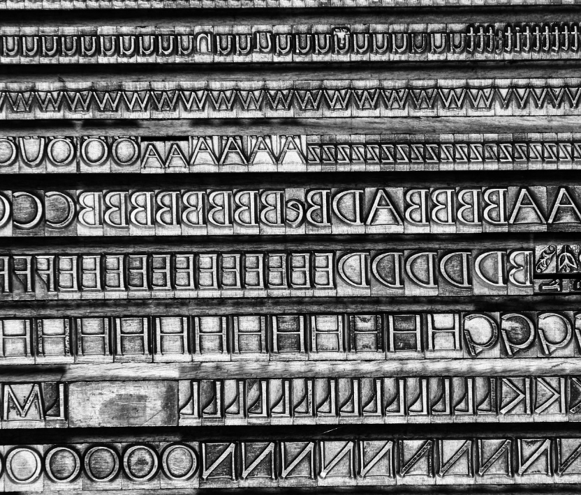 Una macchina da scrivere gialla con tanti fogli bianchi sparsi intorno