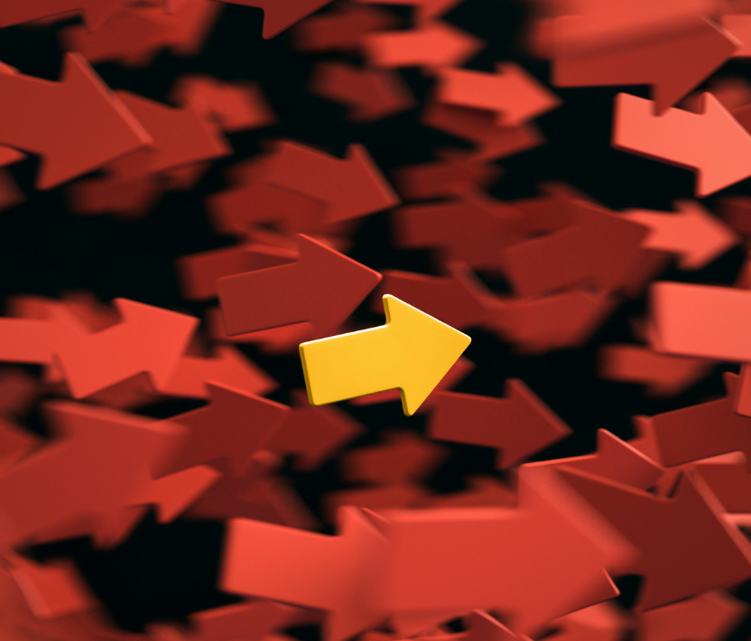 Una macchina da scrivere gialla con tanti fogli bianchi sparsi intorno